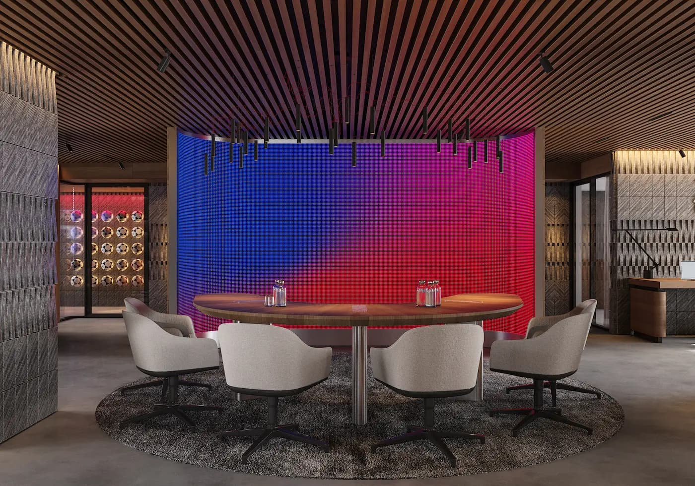 Branded meeting space with red and blue digital wall inside the Barcelona office