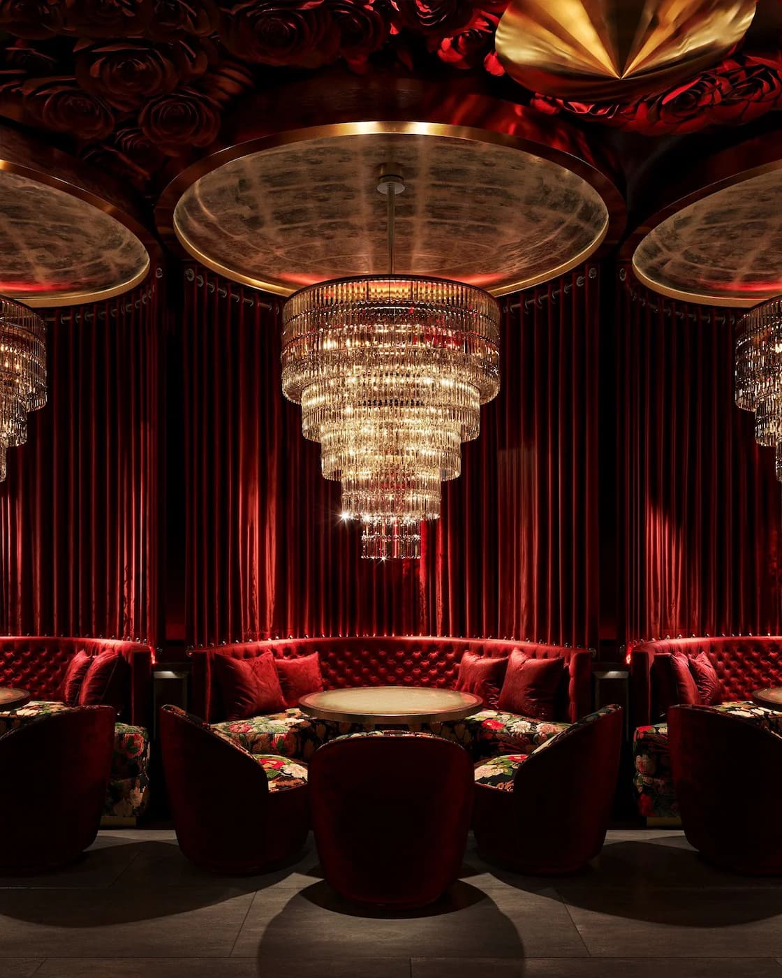 Luxury lounge with cascading crystal chandelier, velvet seating and theatrical red drapery