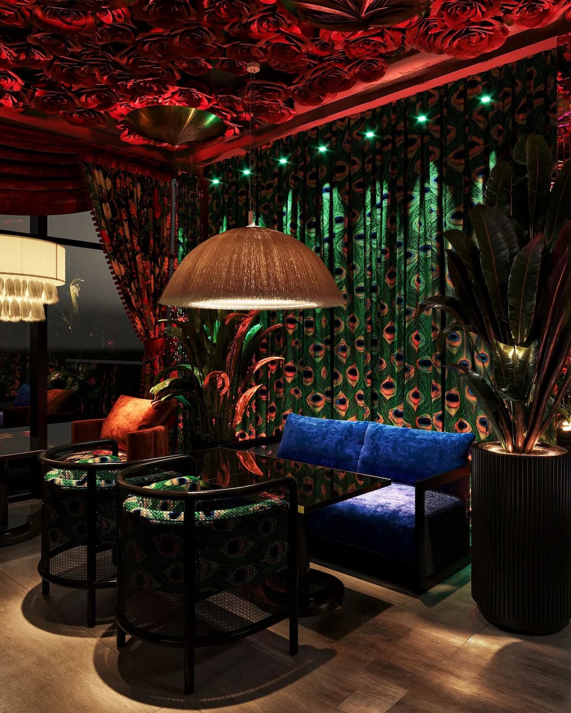 Tropical lounge with emerald green lighting, patterned upholstery and botanical wall details