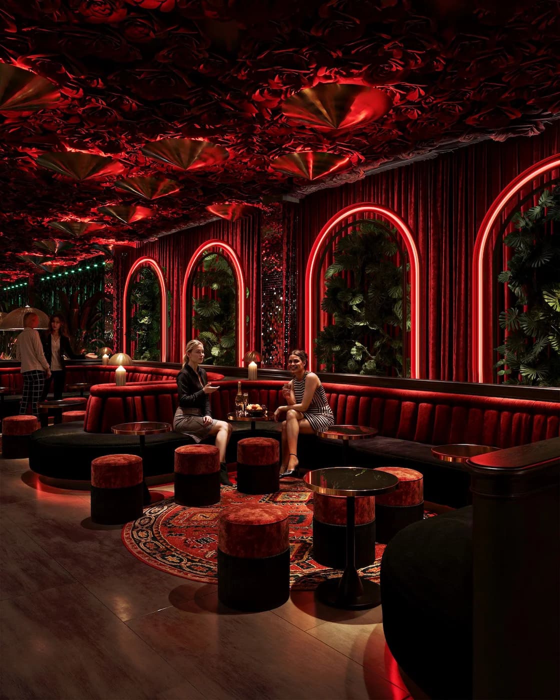 Main dining hall with illuminated arches, red ceiling installation and layered seating