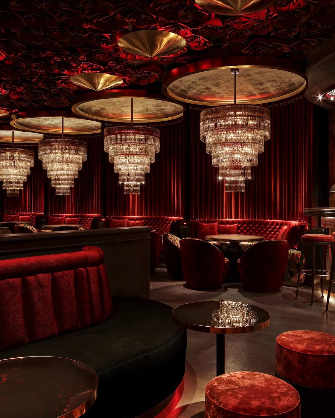 Intimate restaurant lounge with crystal chandeliers, red curtains and velvet furniture