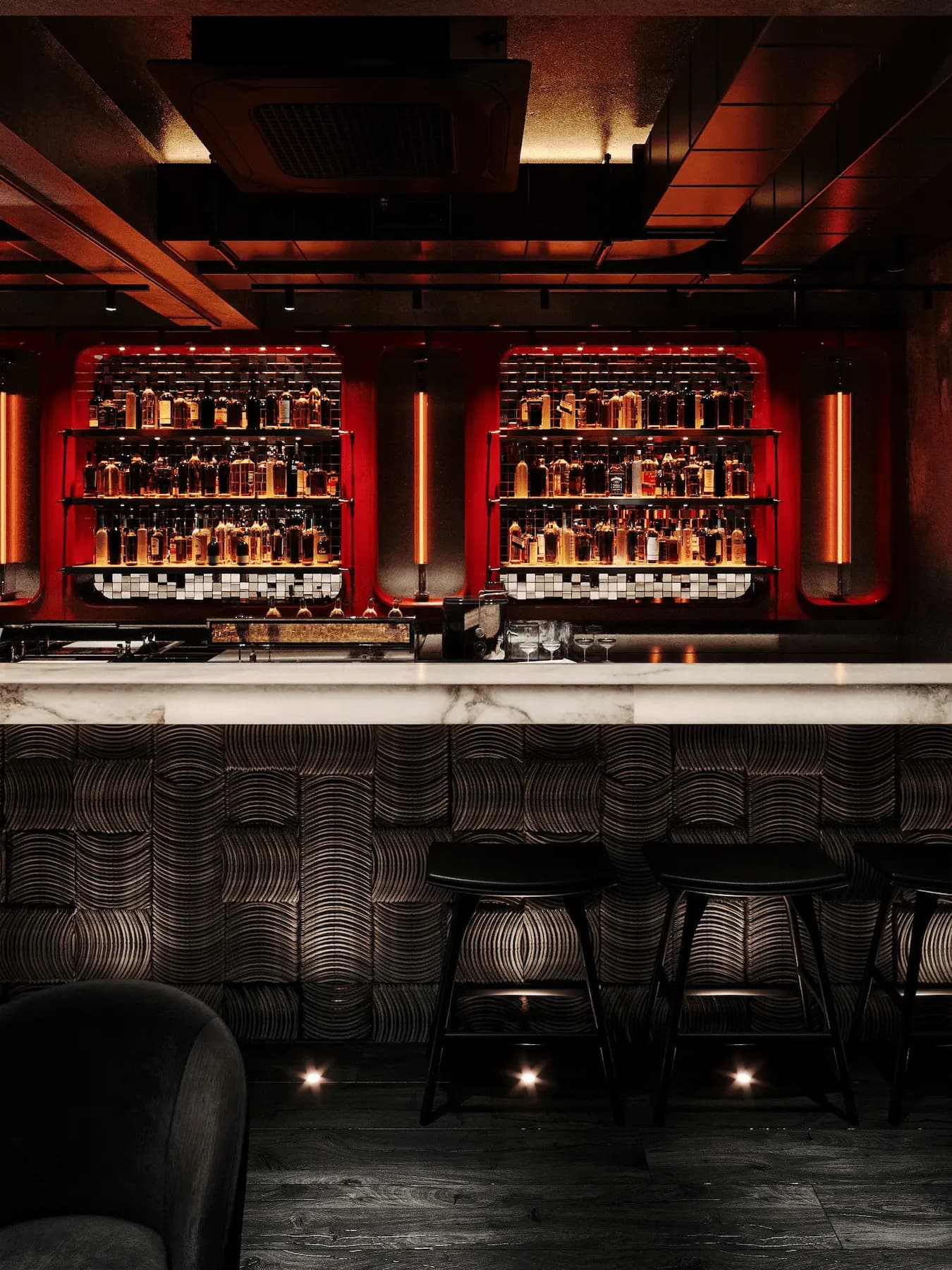 Luxury cocktail bar with illuminated bottle display and bespoke marble counter