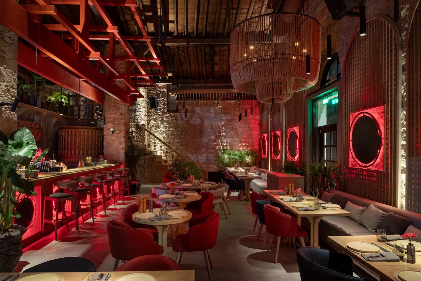 Lila Izakaya dining area featuring raw stone walls, red accents and atmospheric lighting