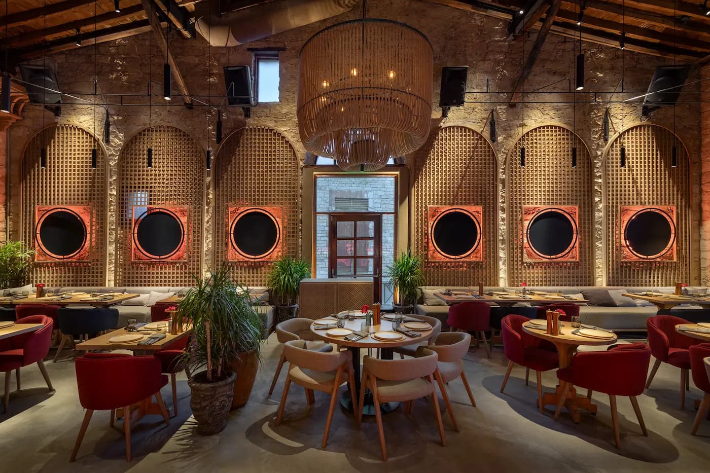 Lila Izakaya interior with textured stone walls, arched openings and intimate seating