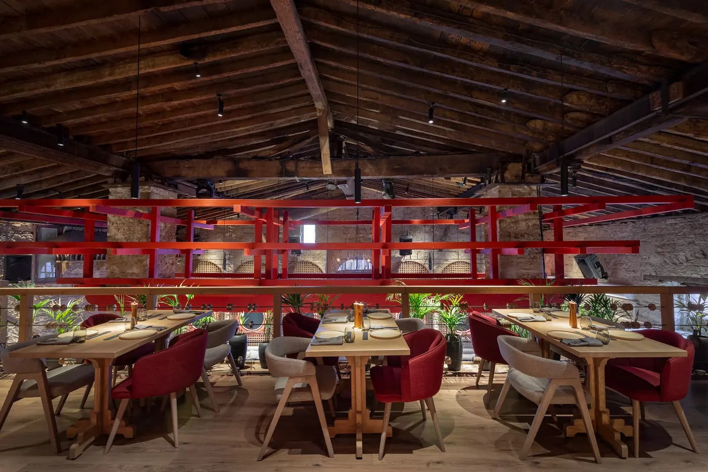 Lila Izakaya restaurant interior with timber ceiling, burgundy seating and layered lighting