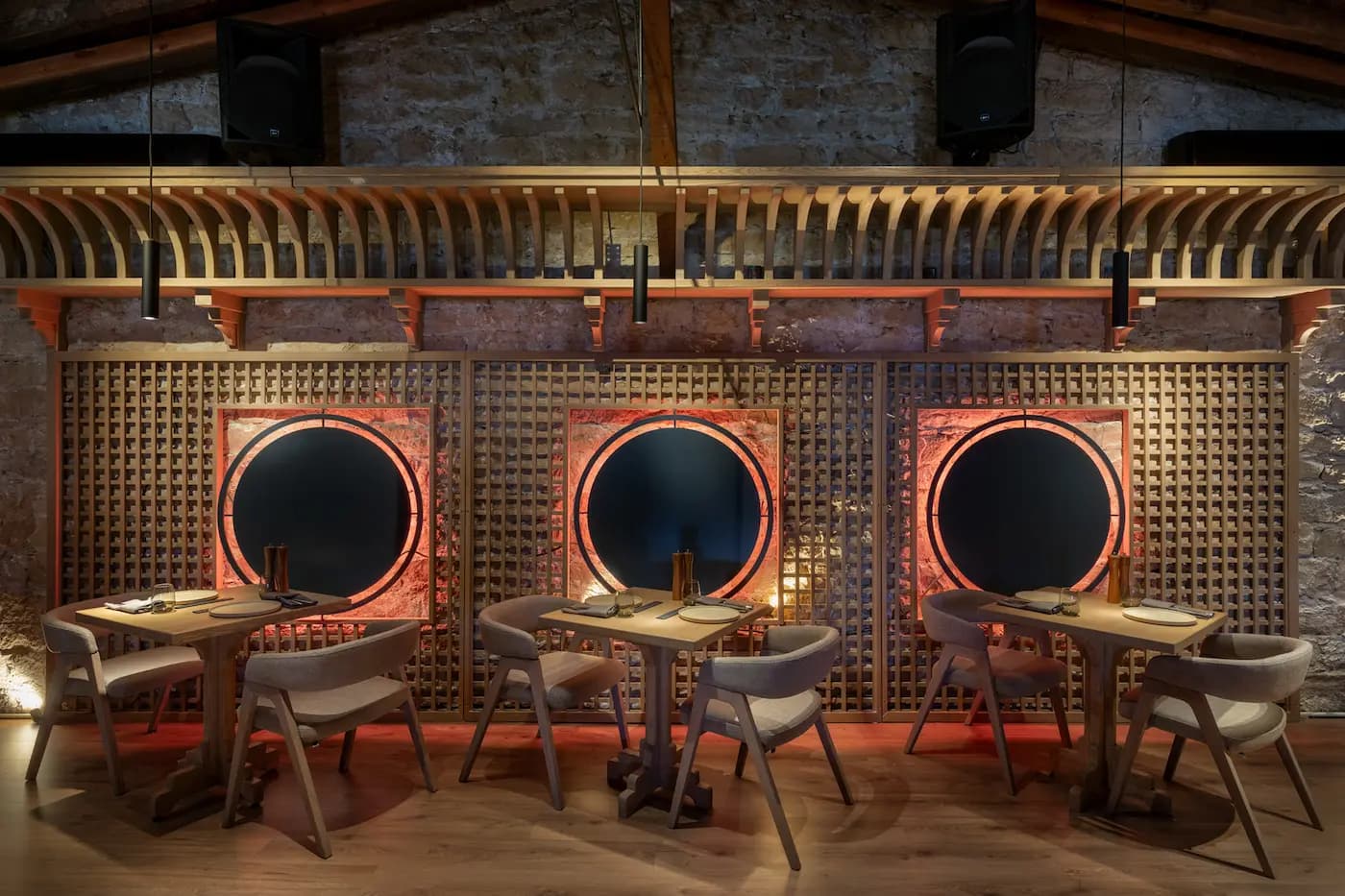 Lila Izakaya textured stone wall with circular openings and integrated architectural lighting