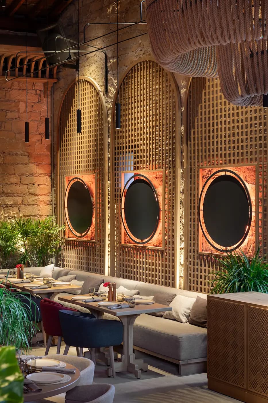 Lila Izakaya stone wall with circular openings and layered architectural lighting