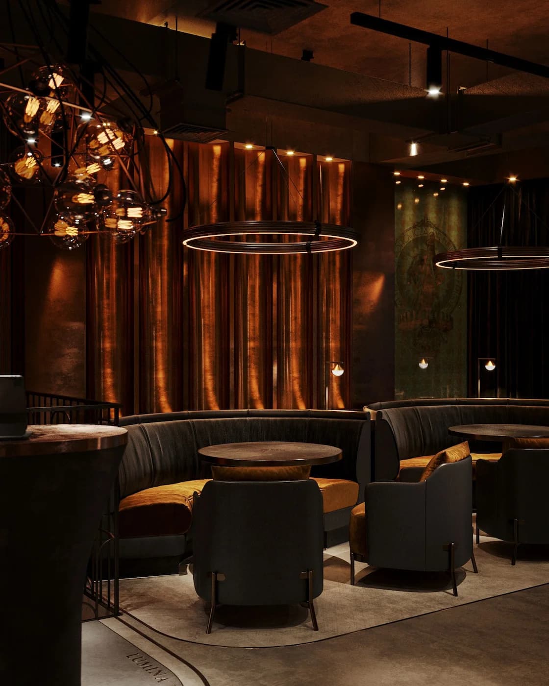 Intimate lounge framed by glowing copper columns and dark upholstery