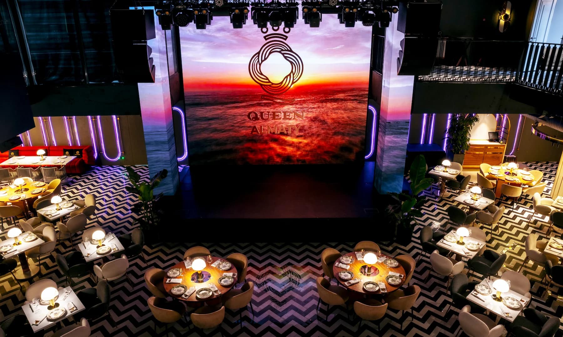 Large event space with sunset imagery displayed across the digital stage