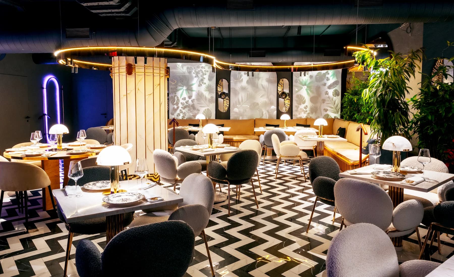 Luxury dining area with sculptural partitions, chandeliers and graphic flooring