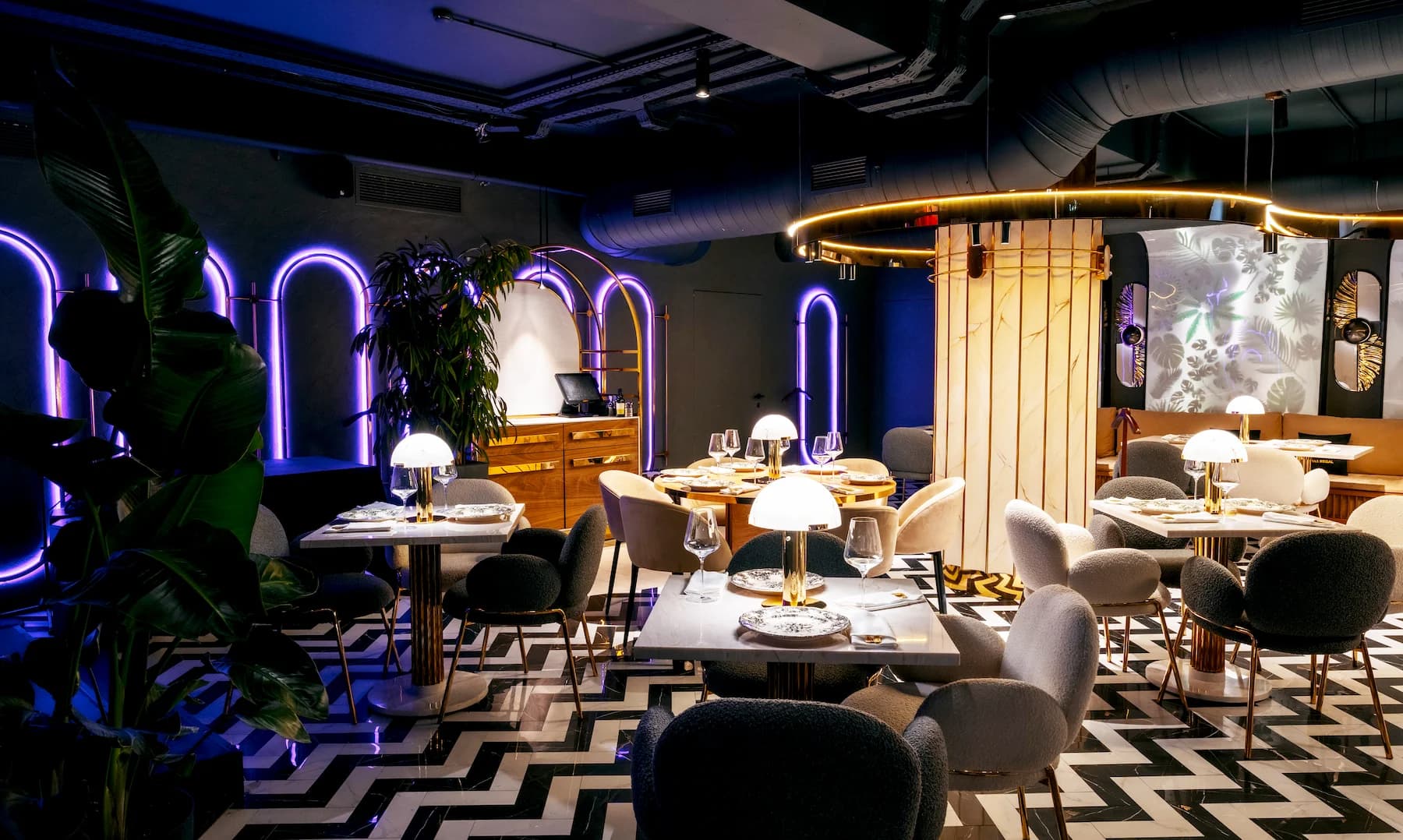 Light-filled restaurant interior with soft seating, natural materials and panoramic glazing