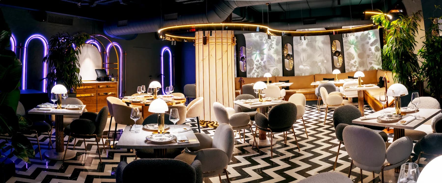 Refined dining room with marble tables, upholstered chairs and layered lighting
