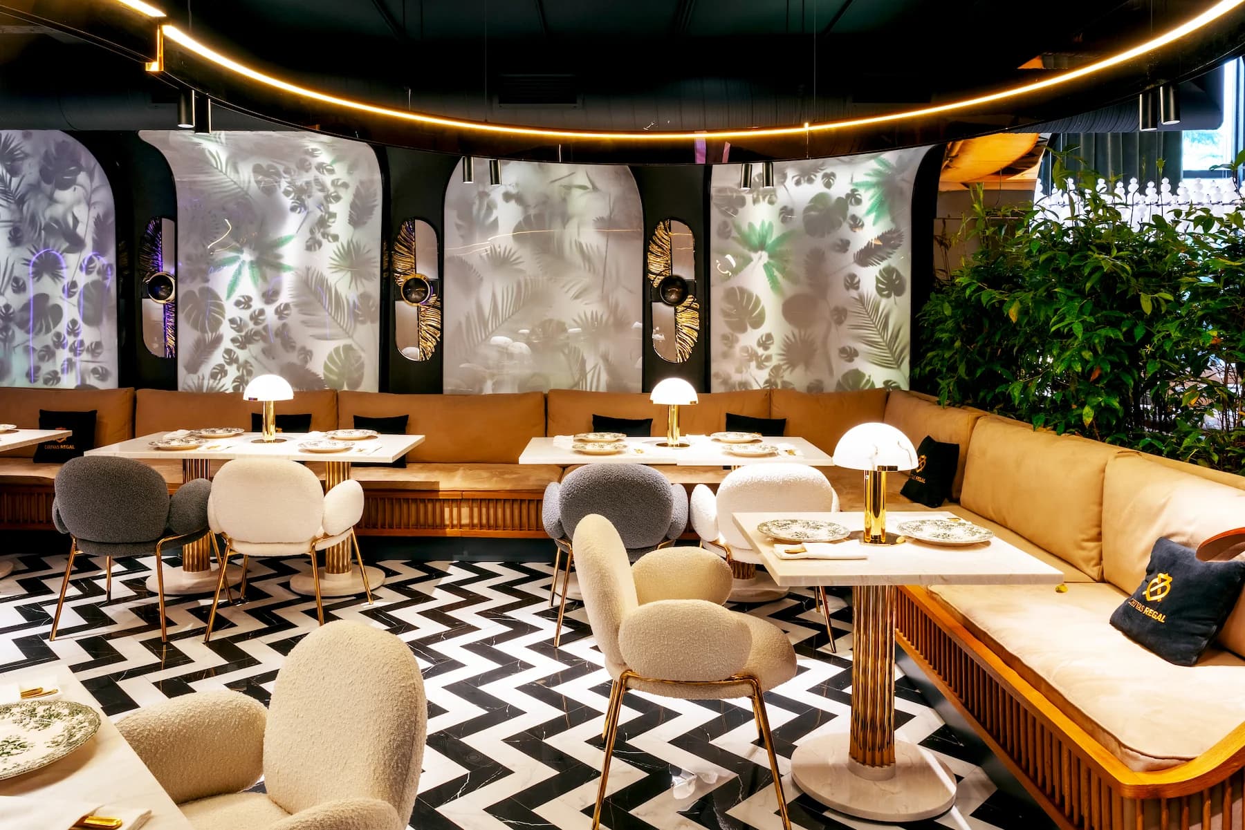 Queen restaurant seating area with sculptural arches and contemporary chandeliers