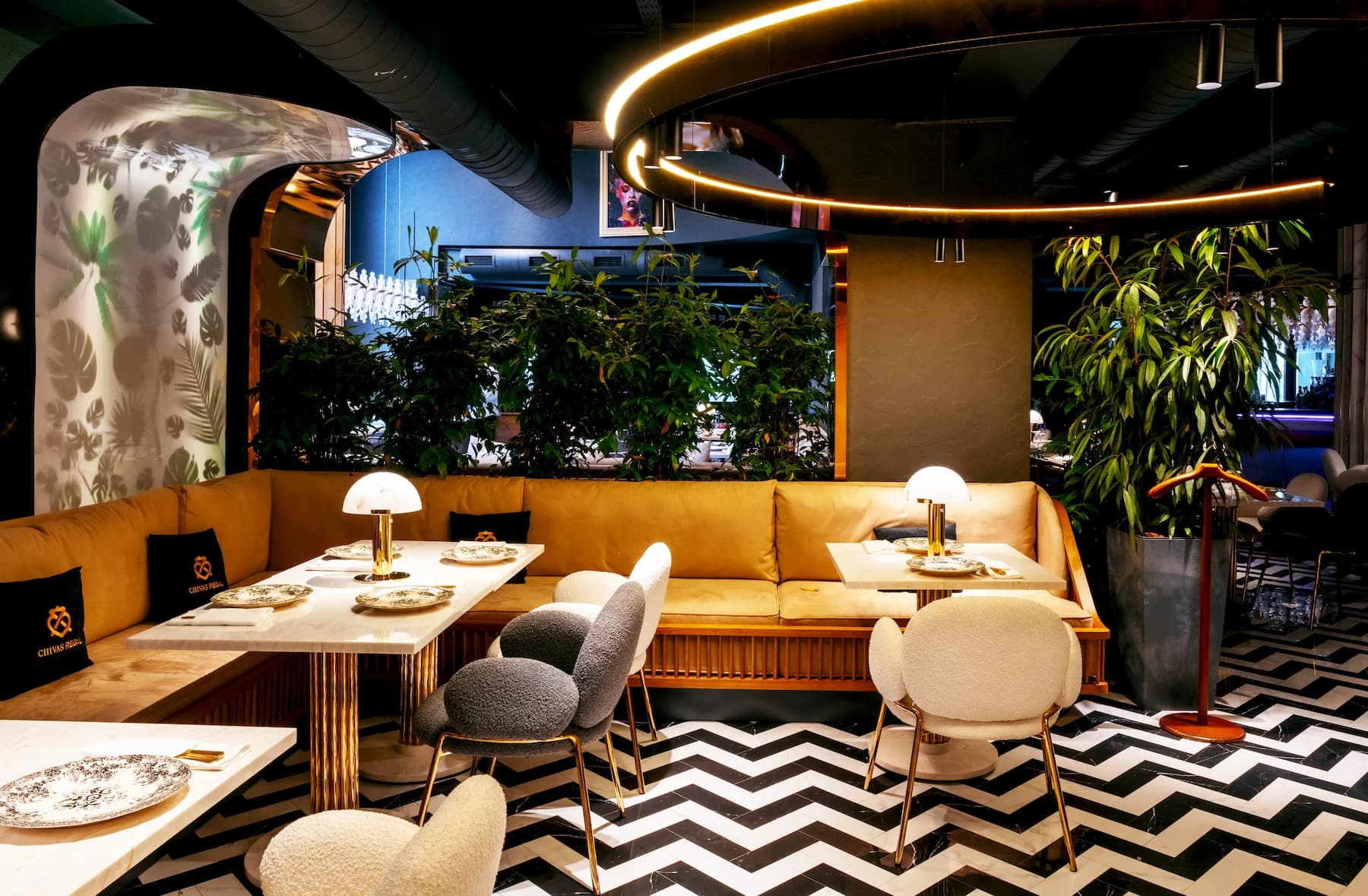 Restaurant interior with illuminated bottle displays, pale furniture and graphic flooring