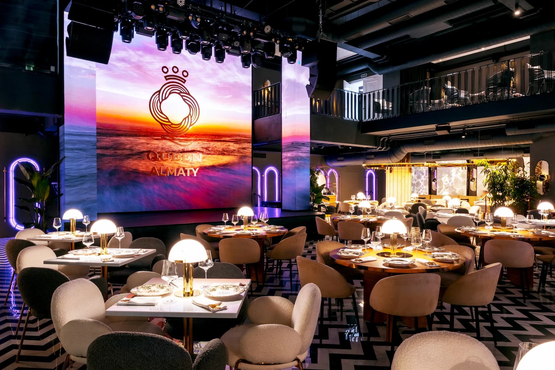 Ballroom stage with layered lighting, sculptural ceiling details and luxury seating