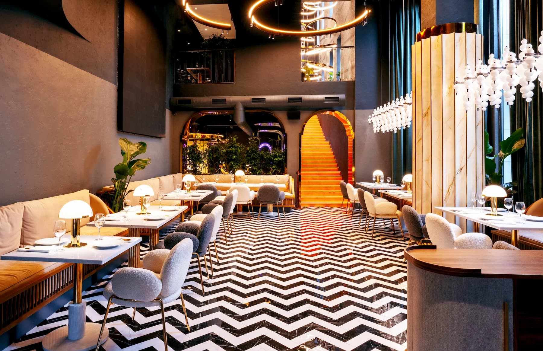 Queen central bar with luminous counter, decorative bottles and sculptural ceiling feature