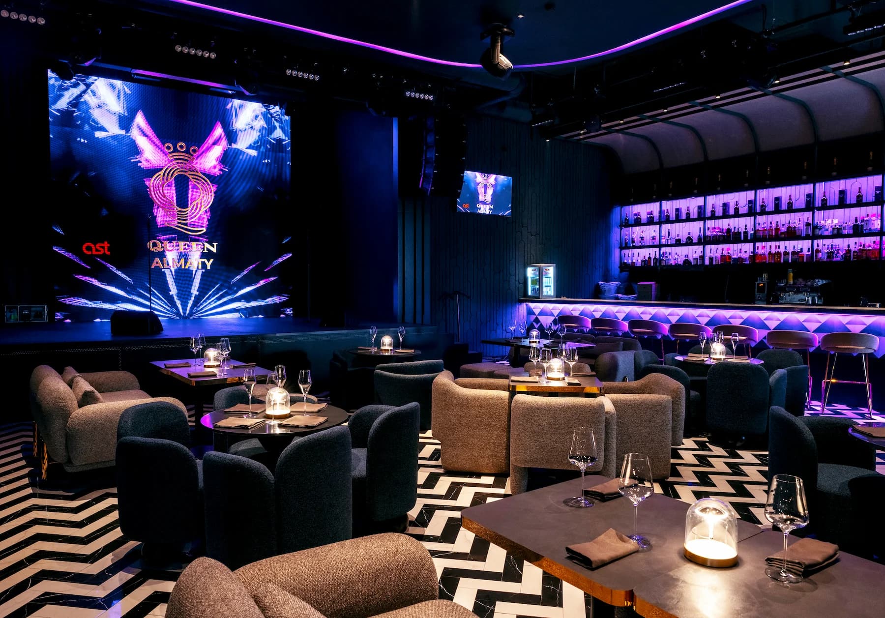 Nightlife interior with black walls, modular seating and integrated blue lighting