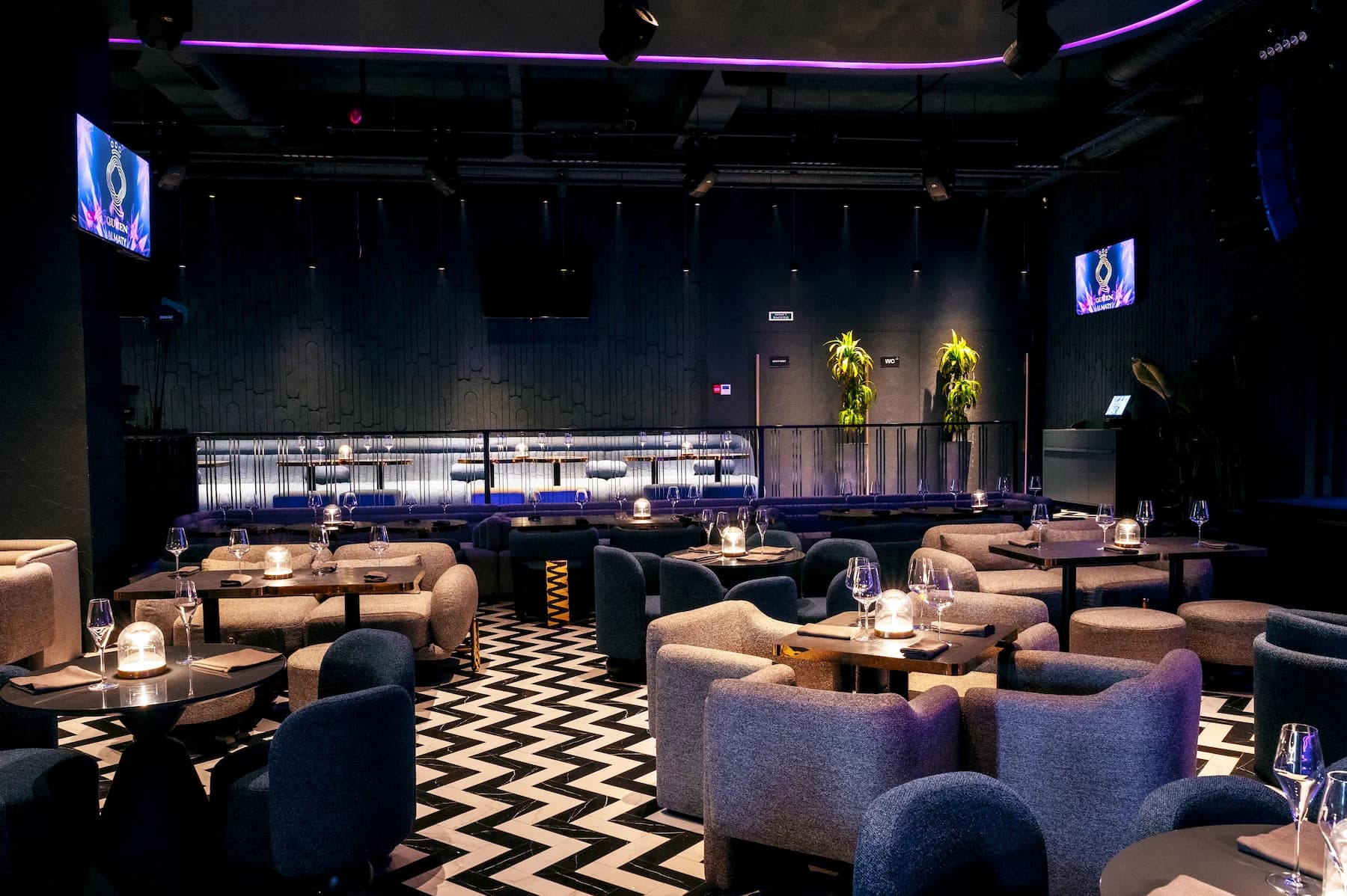 Queen karaoke hall with large digital screen and lounge-style seating