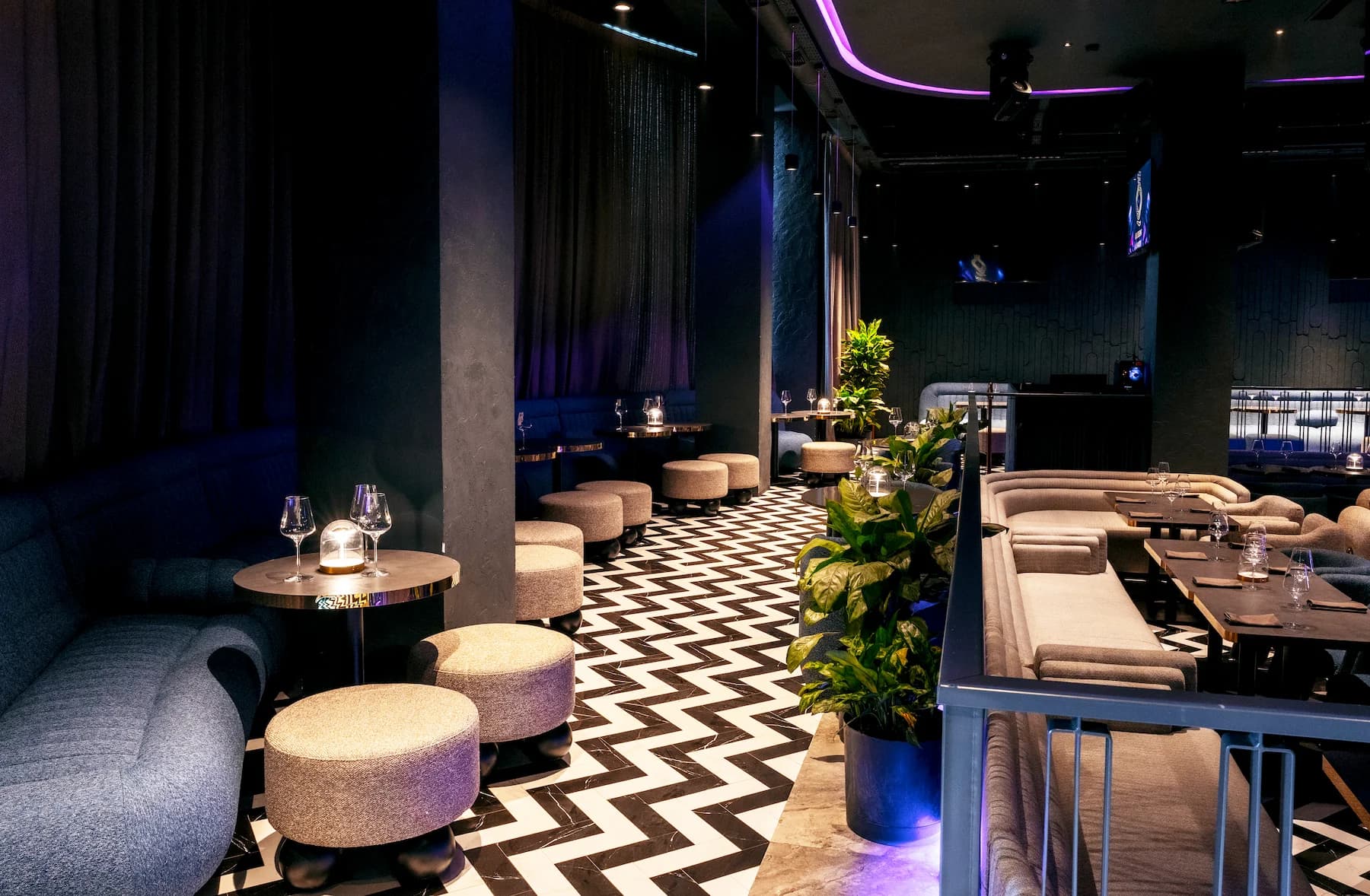 Entertainment space with vivid digital artwork, sofas and patterned flooring