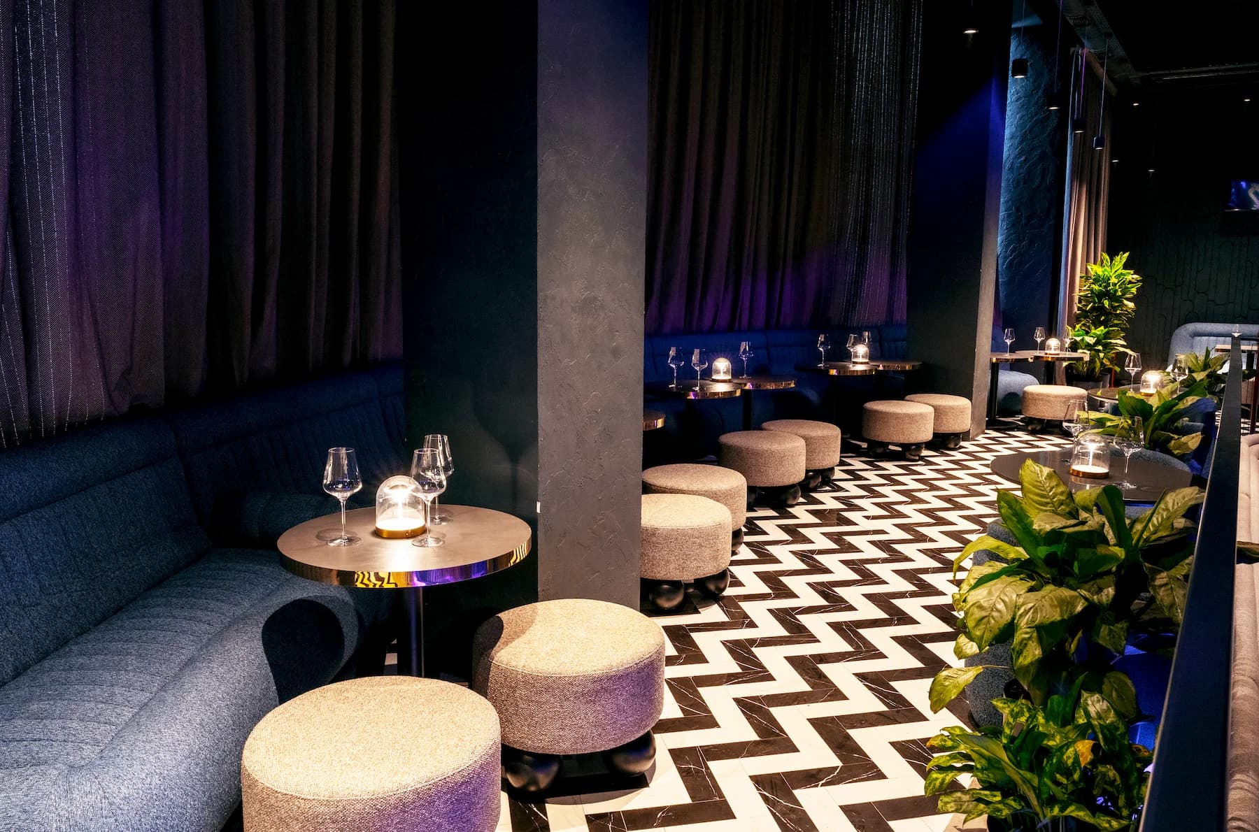 Karaoke lounge with stage lighting, upholstered booths and multimedia screens