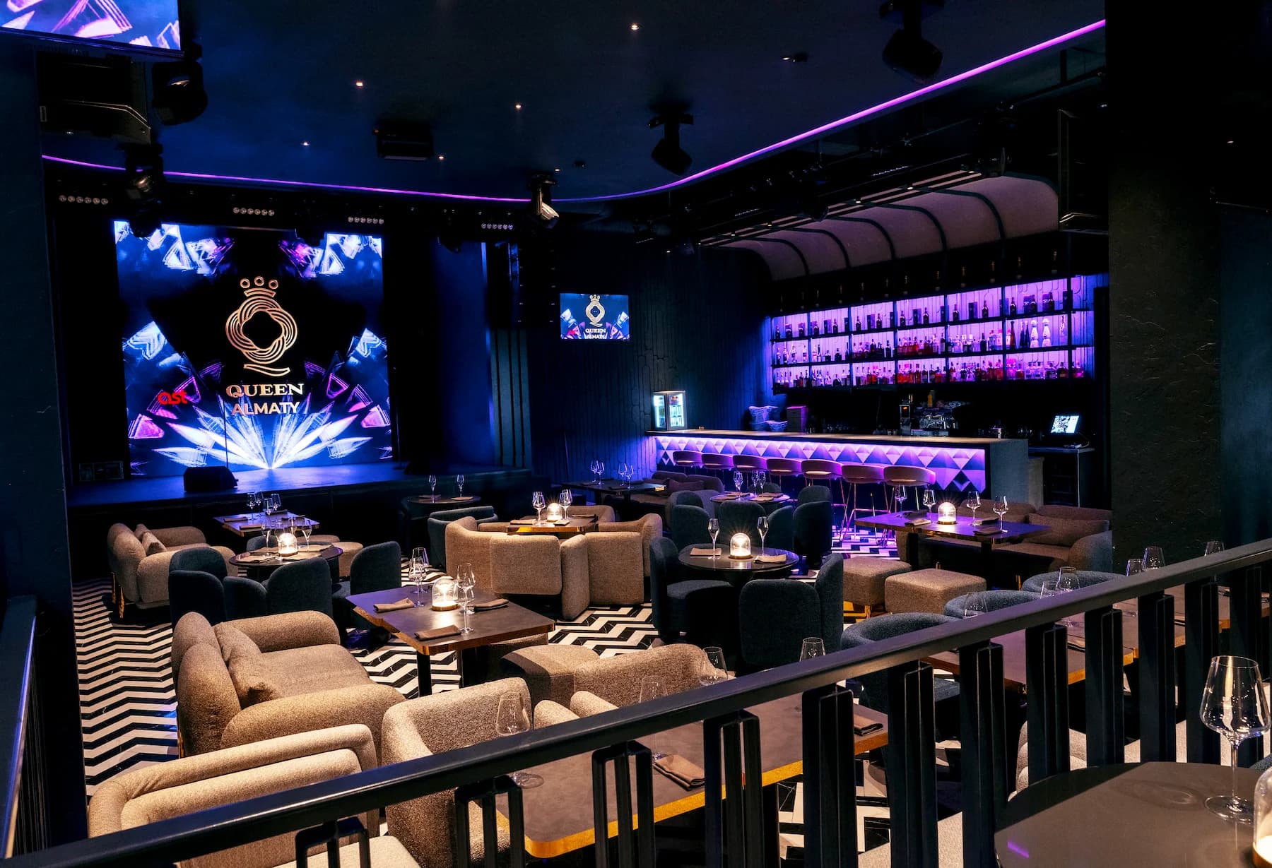 Intimate karaoke booth with dark curtains, low lighting and upholstered banquette