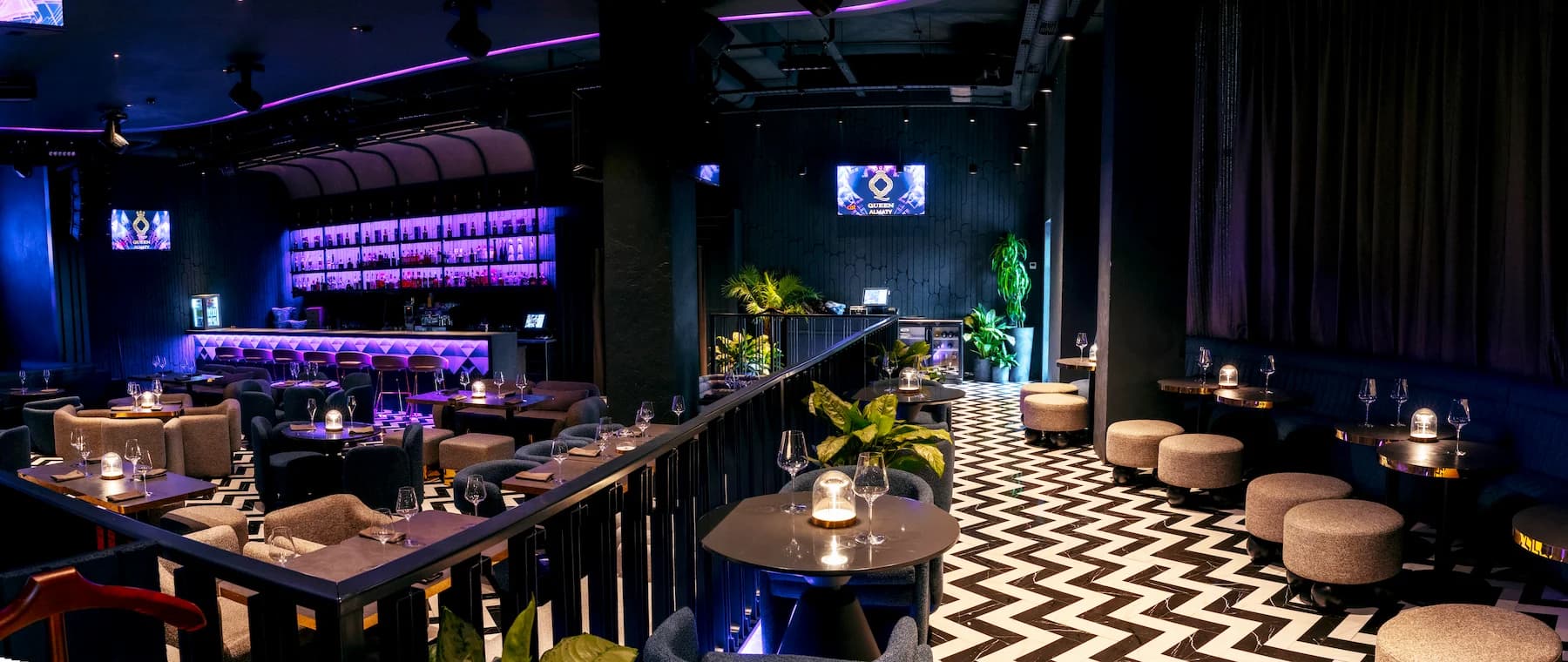 Private lounge with curved sofa, table lighting and black-and-white flooring