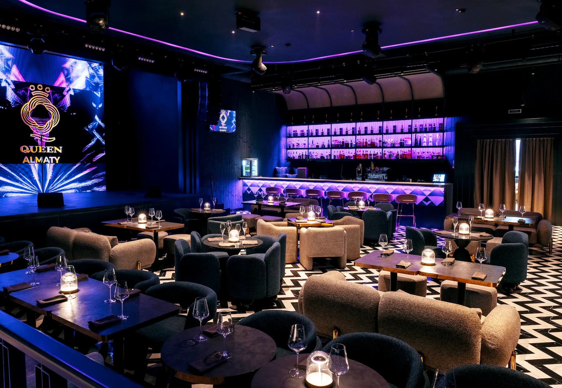 Upper-level seating area overlooking the karaoke lounge and illuminated bar