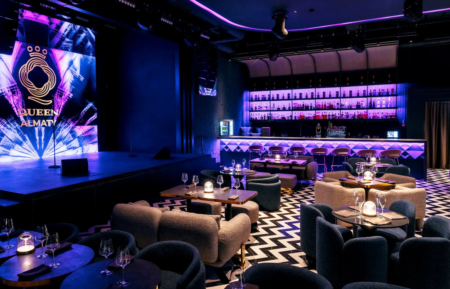 Queen entertainment space with planted balustrade, digital screens and lounge seating