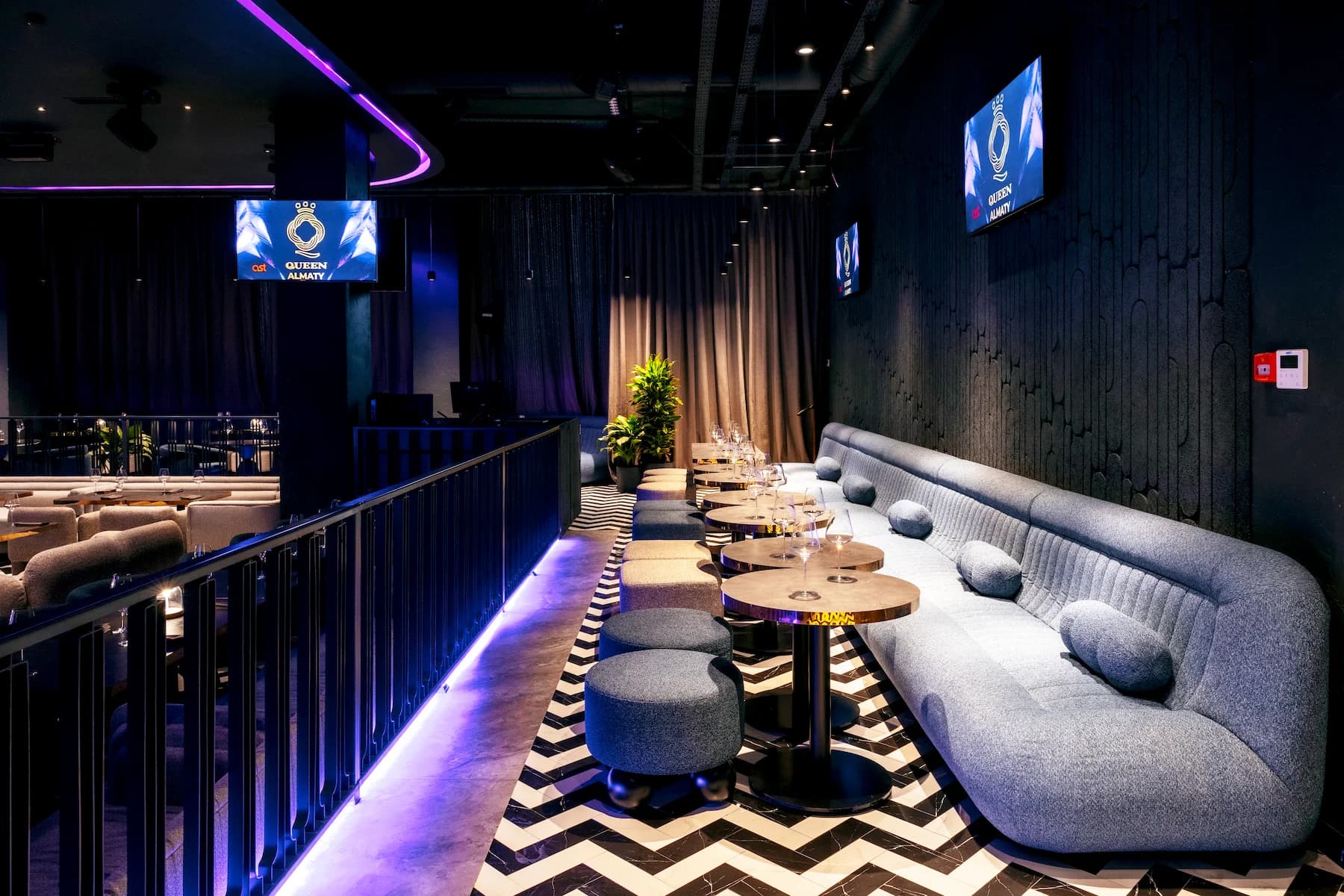 Long communal table with integrated blue lighting inside the Queen karaoke area