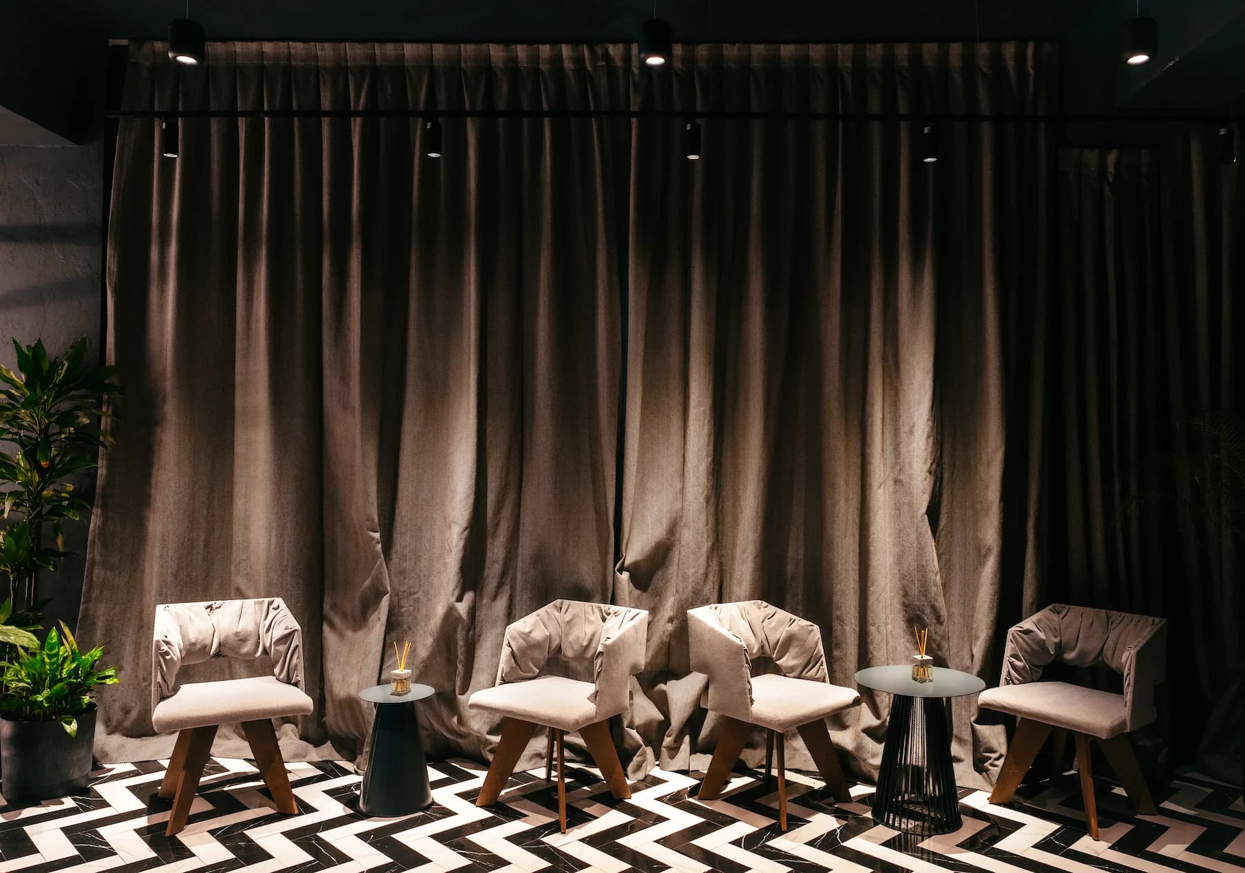 Karaoke bar interior with illuminated shelving, dark furniture and blue accent light