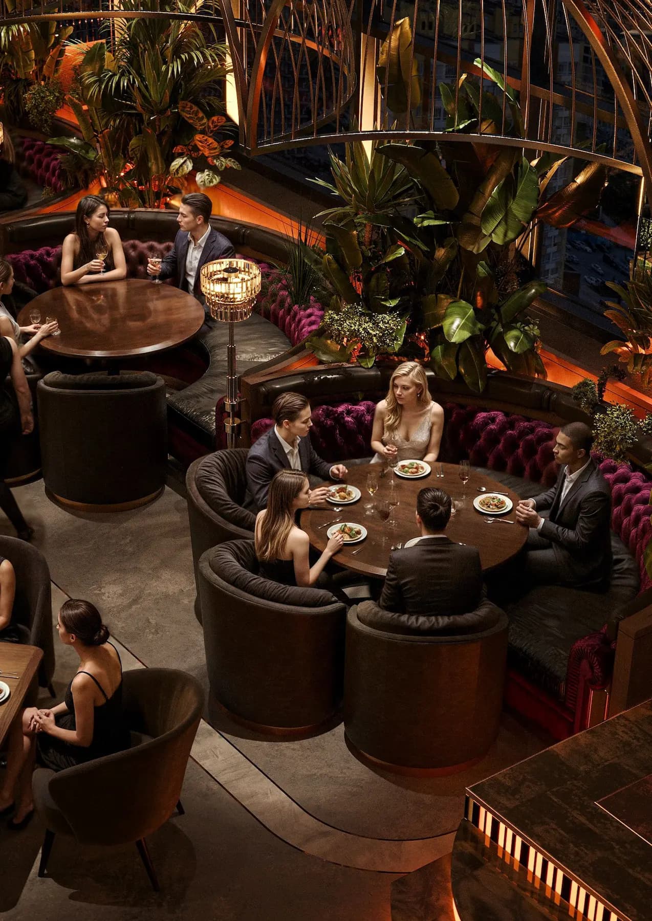 Aerial view of round velvet booth seating and dark timber tables in the Zaxi Restaurant dining hall