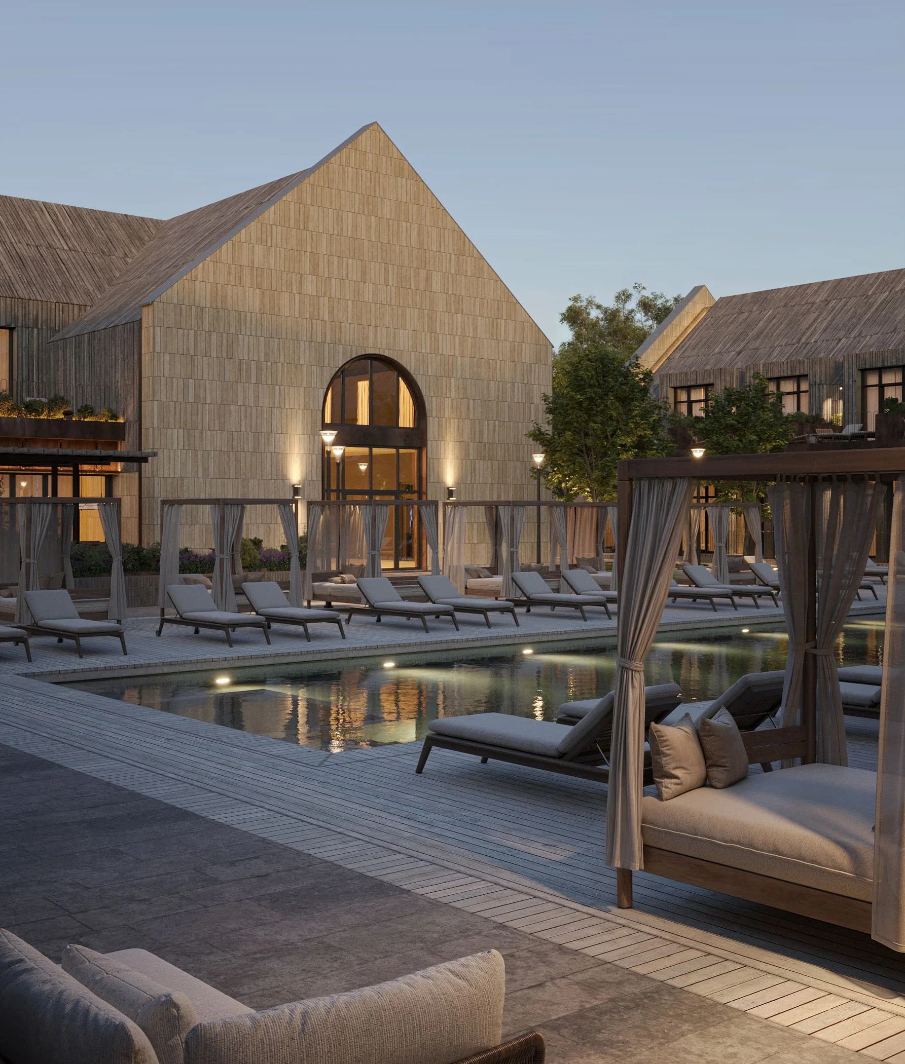 Poolside daybed lounge area against the stone facade of the Shampan winery