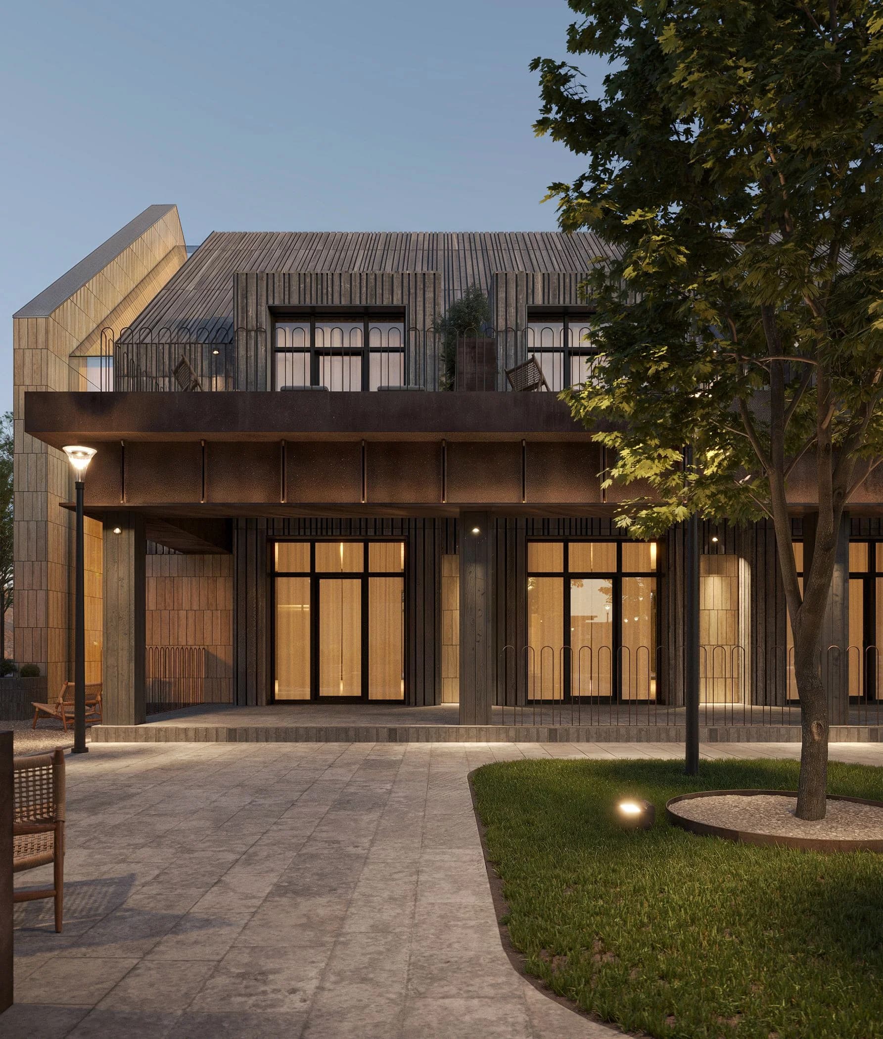 Building facade with large glazed windows and warm interior light at dusk
