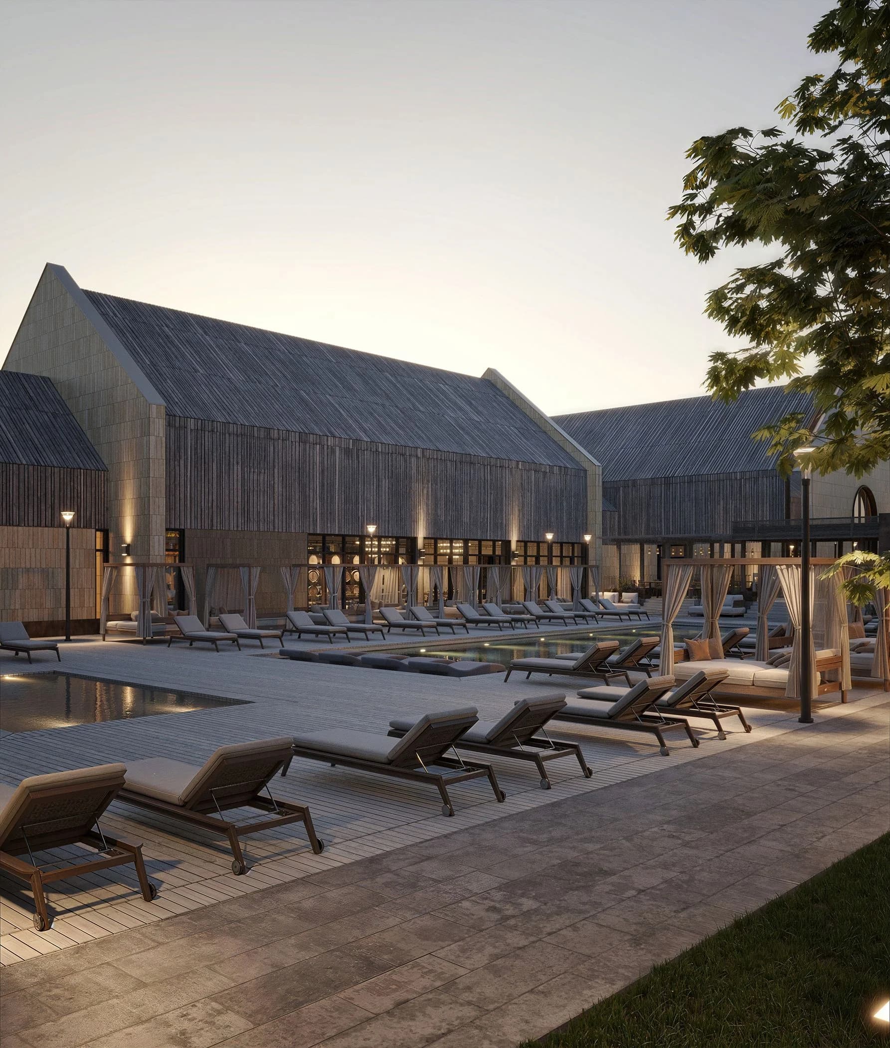 Sun loungers by the pool along the winery's stone facade at dusk