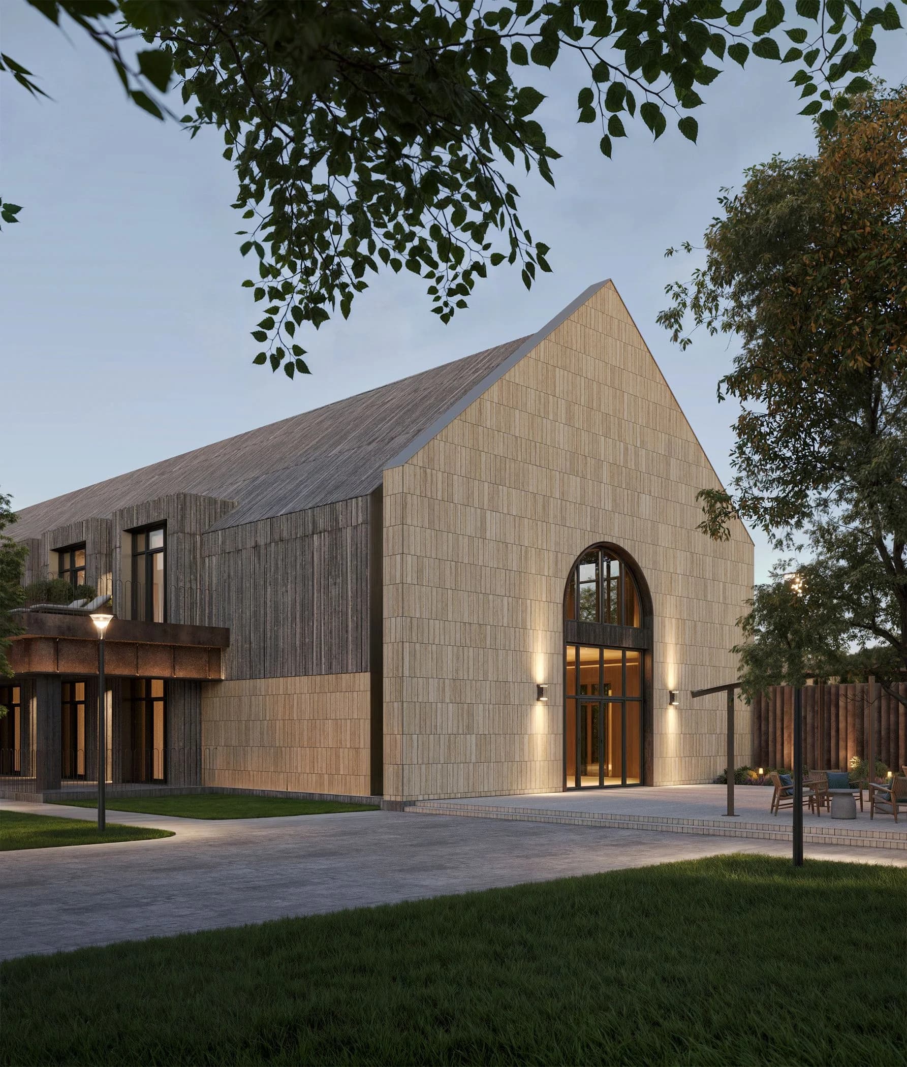 Stone building facade with a tall arched window lit at dusk