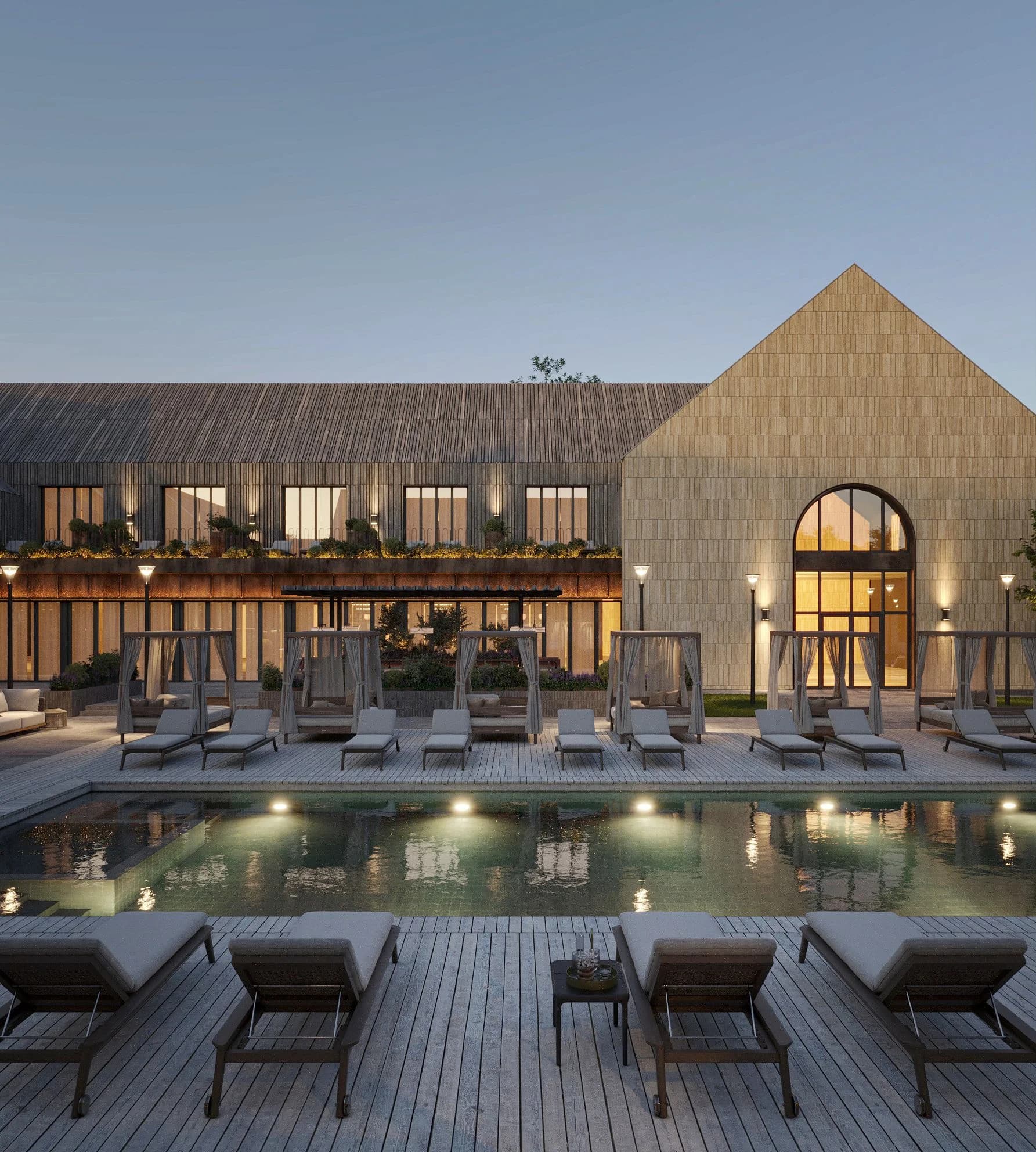 Poolside terrace with a building glowing from lit windows at dusk