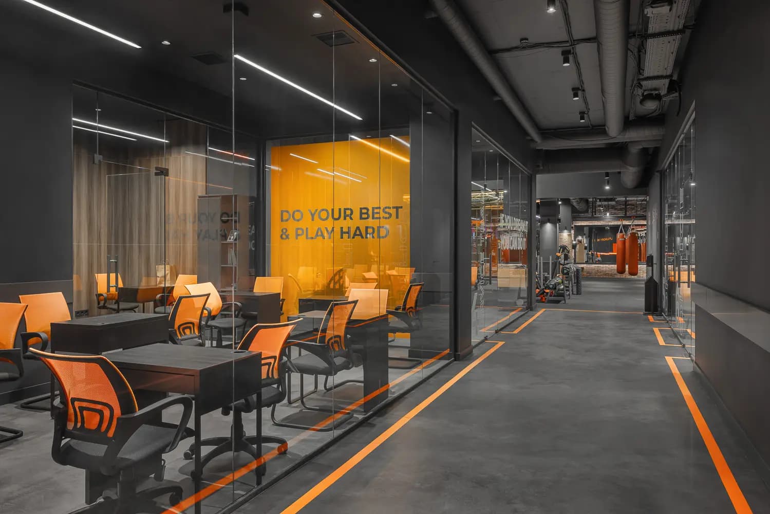 Glass-fronted consultation lounge with orange seating and graphic wall lettering.