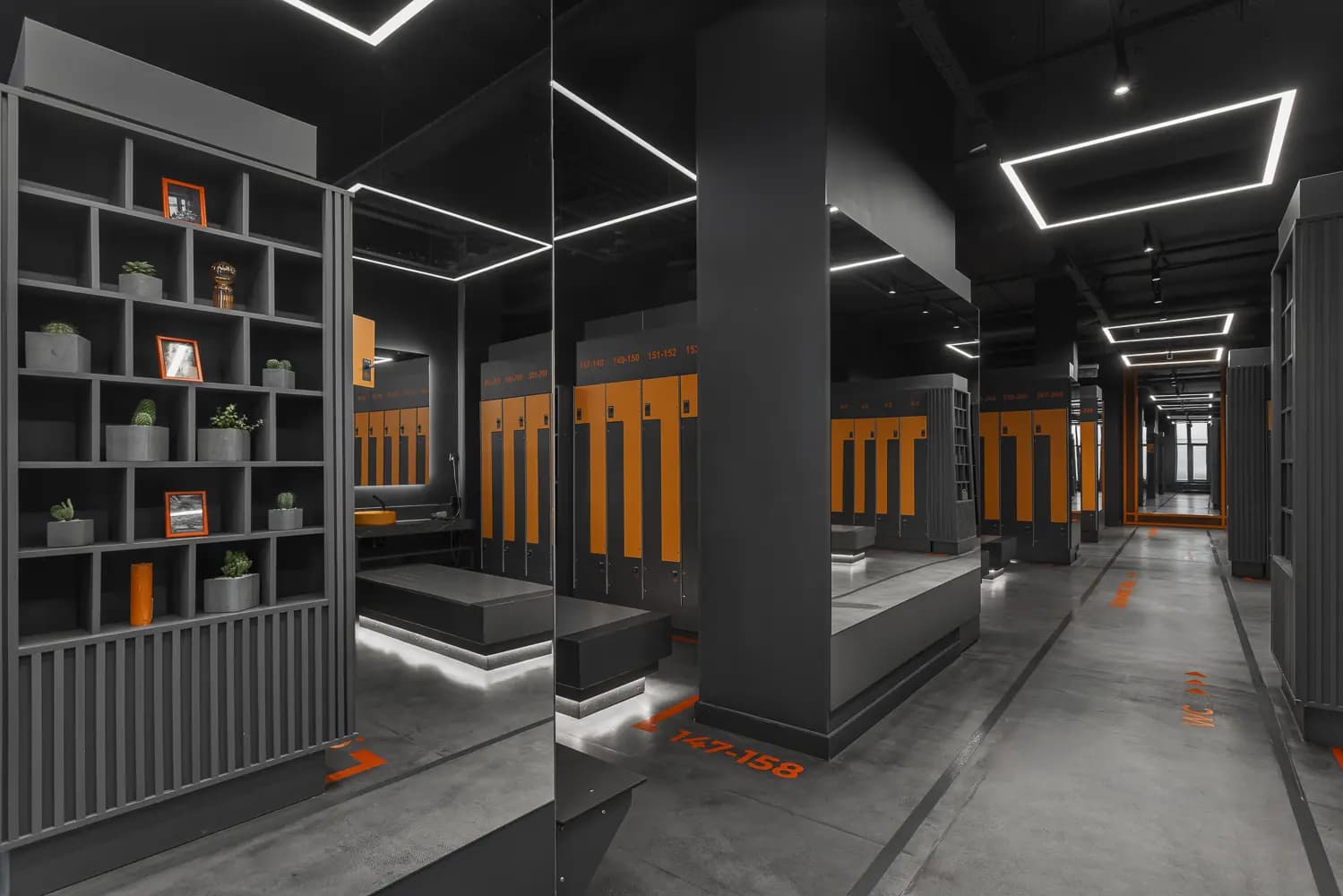Changing area with black metal screens, open storage and vivid orange details.