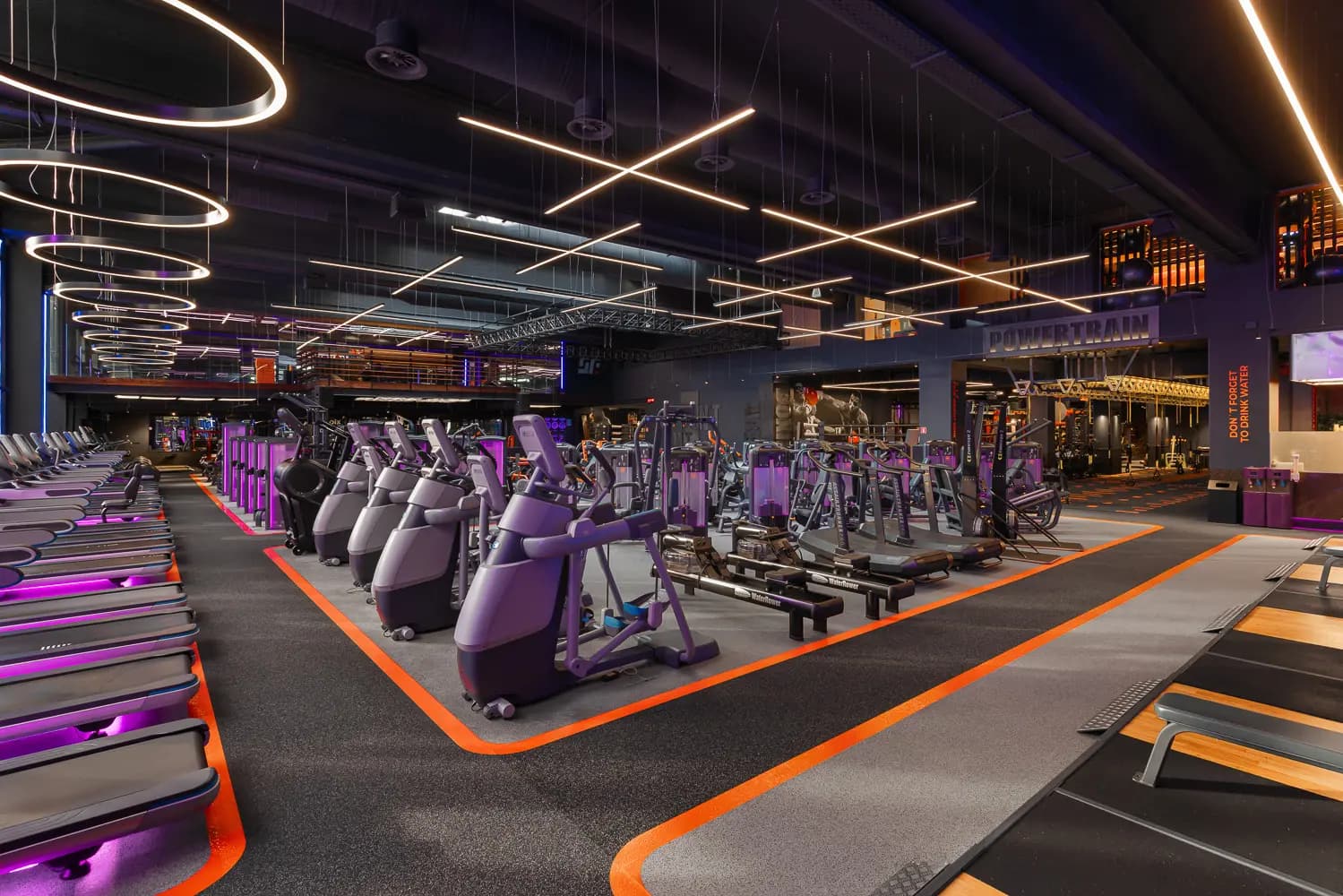 Neon-lit main space at Synergy Fitness & Spa in Odesa with red and blue ceiling installations.