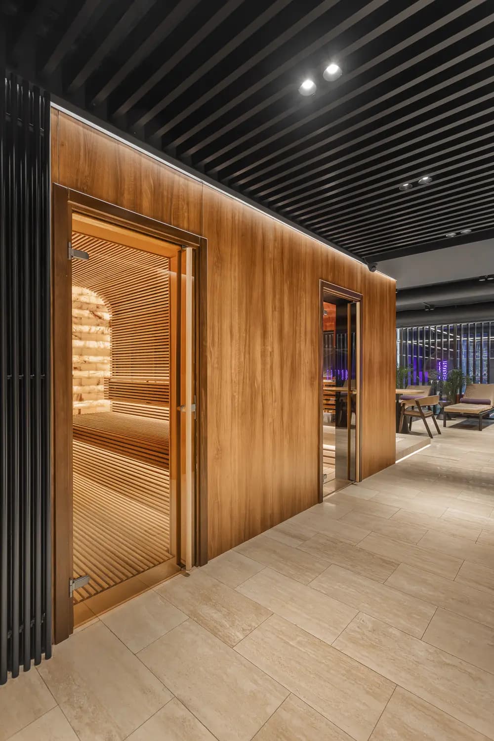 Timber-lined spa corridor with a sculptural arched entrance to the sauna.