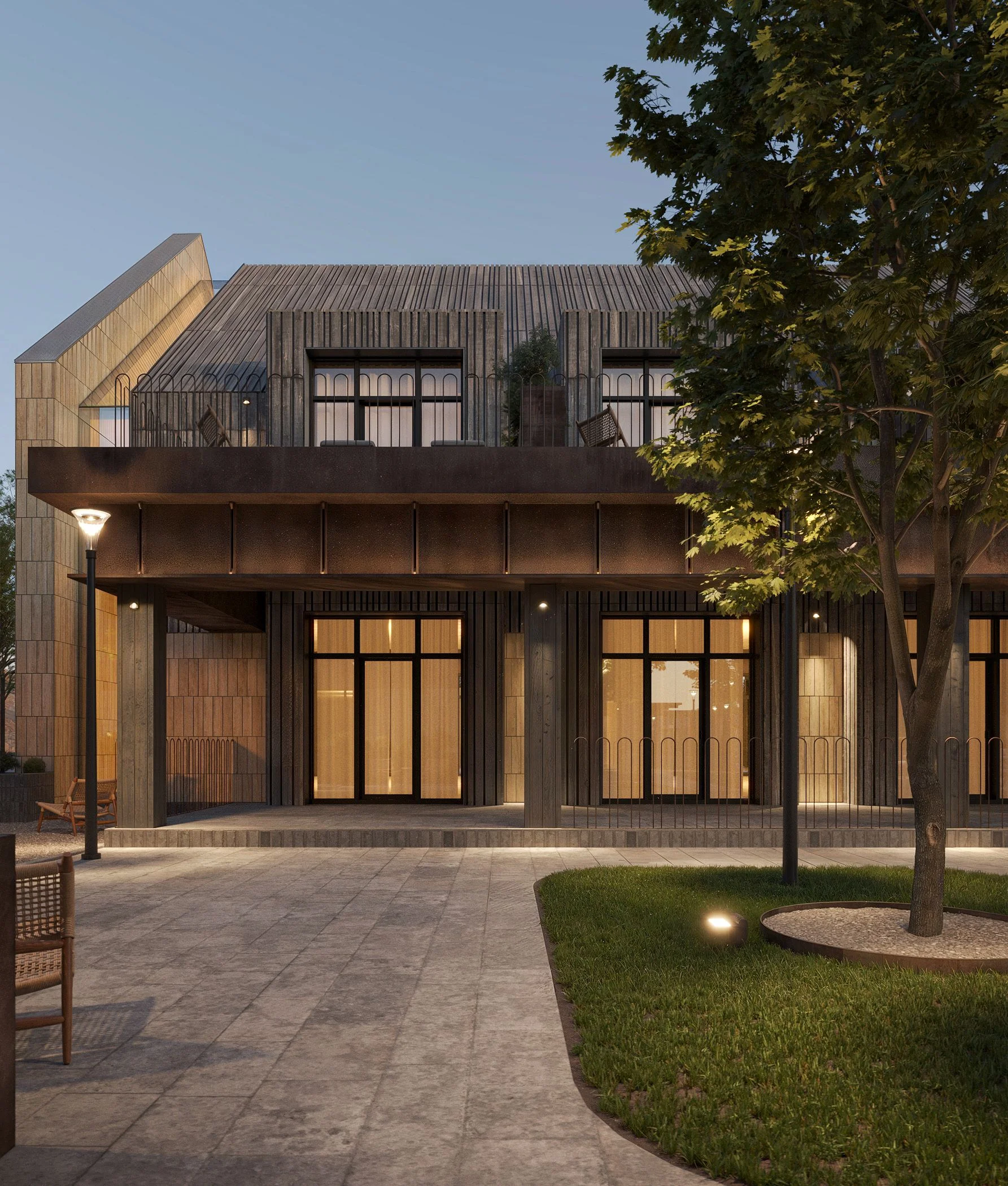 Building facade with large glazed windows and warm interior light at dusk