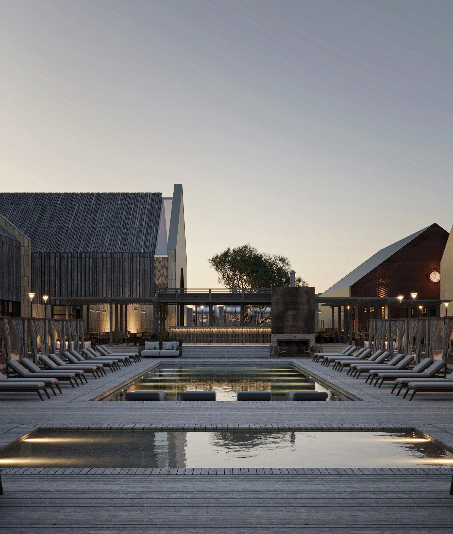 Pool at dusk with sun loungers against gable-roofed buildings